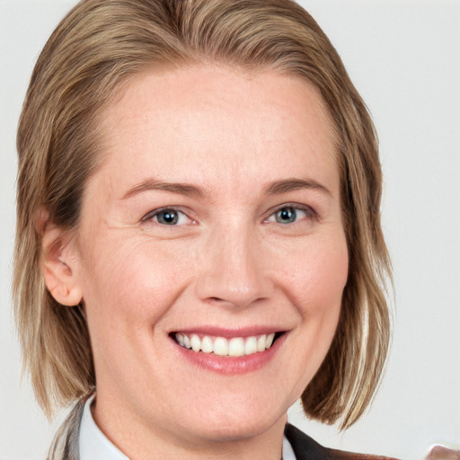 Joyful white adult female with medium  brown hair and blue eyes