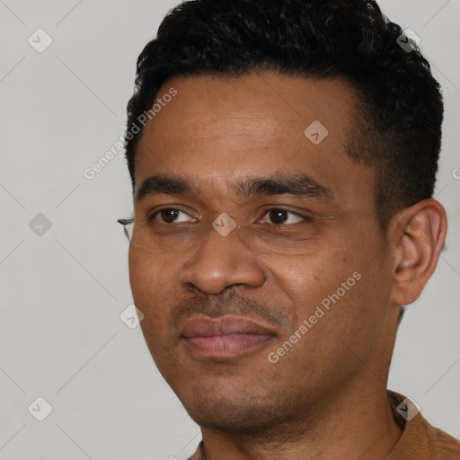 Joyful black young-adult male with short  black hair and brown eyes