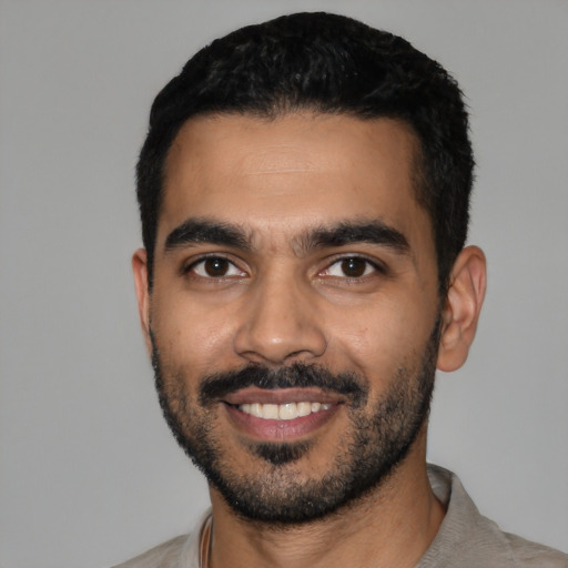 Joyful latino young-adult male with short  black hair and brown eyes