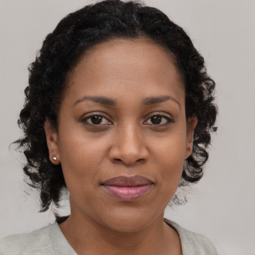Joyful black young-adult female with medium  brown hair and brown eyes