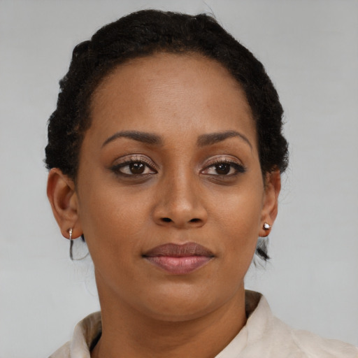 Joyful black young-adult female with short  brown hair and brown eyes