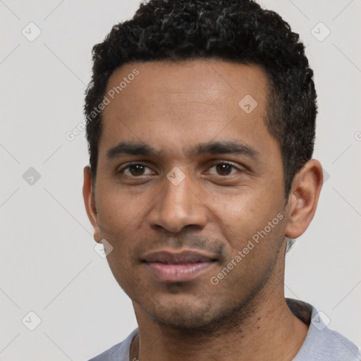 Joyful black young-adult male with short  black hair and brown eyes