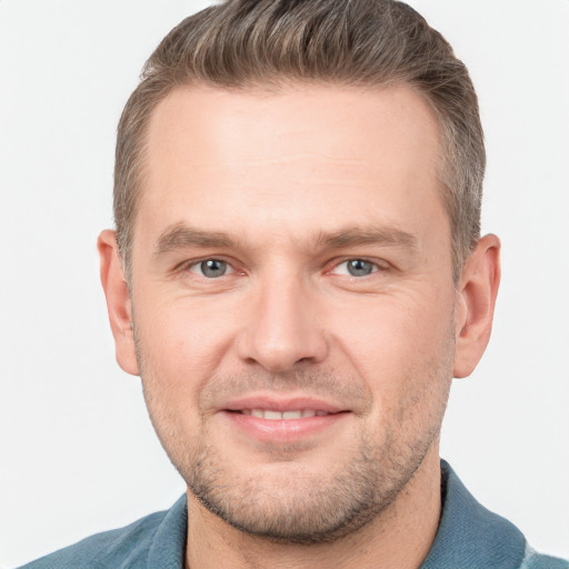 Joyful white young-adult male with short  brown hair and grey eyes