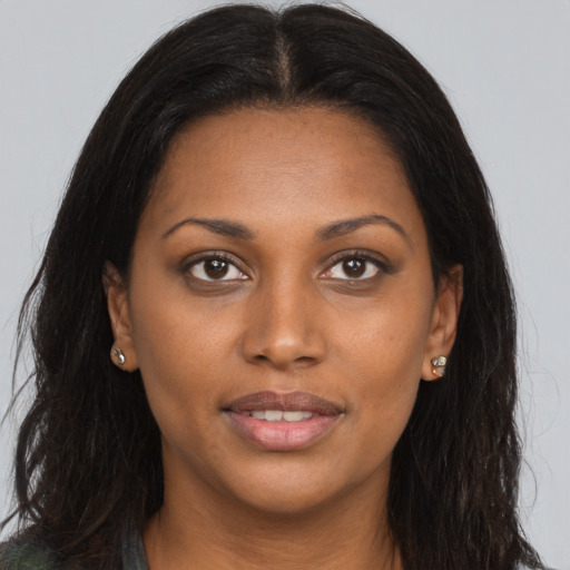 Joyful black young-adult female with long  brown hair and brown eyes