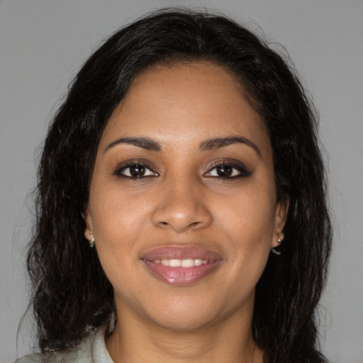Joyful black young-adult female with long  brown hair and brown eyes