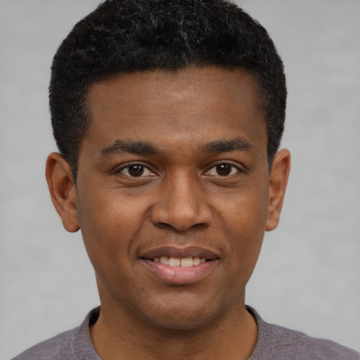 Joyful black young-adult male with short  black hair and brown eyes