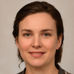 Joyful white young-adult female with medium  brown hair and grey eyes