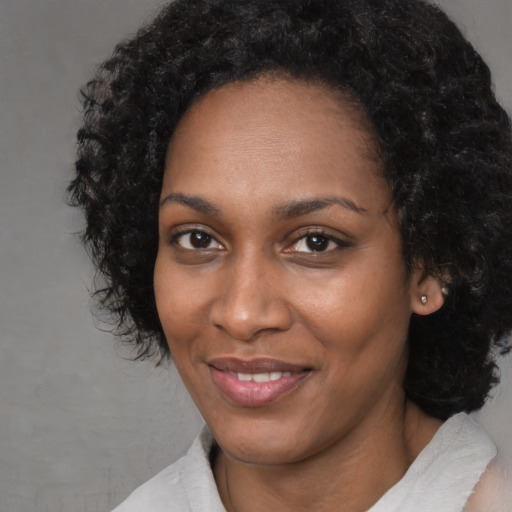 Joyful black young-adult female with short  black hair and brown eyes