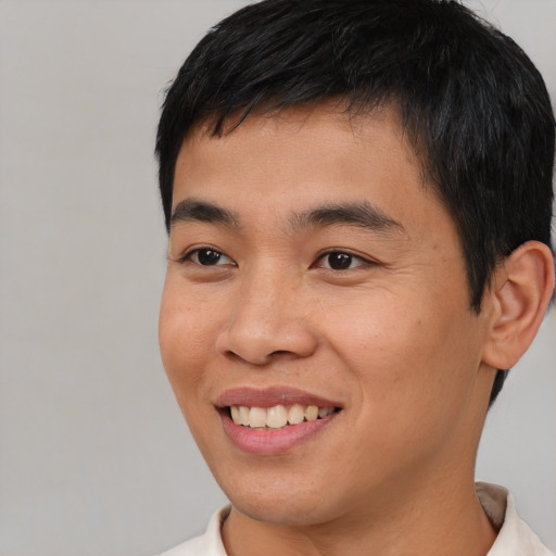 Joyful asian young-adult male with short  black hair and brown eyes