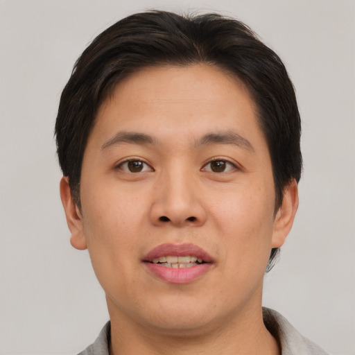 Joyful asian young-adult male with short  brown hair and brown eyes