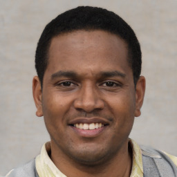 Joyful latino young-adult male with short  black hair and brown eyes