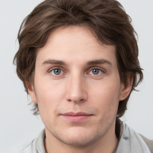 Joyful white young-adult male with medium  brown hair and grey eyes