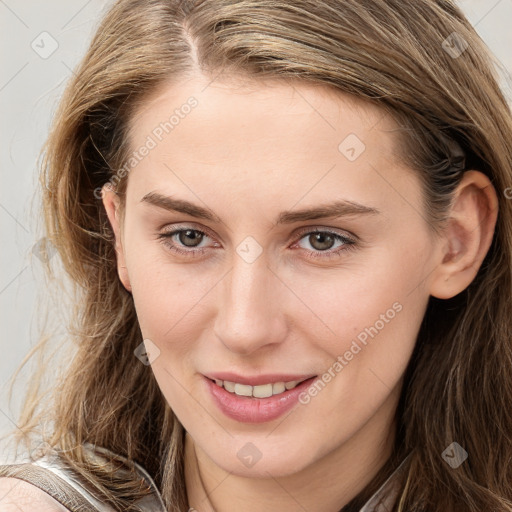 Joyful white young-adult female with long  brown hair and blue eyes