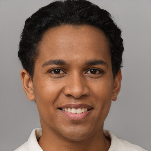 Joyful latino young-adult male with short  black hair and brown eyes