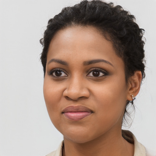 Joyful black young-adult female with long  brown hair and brown eyes