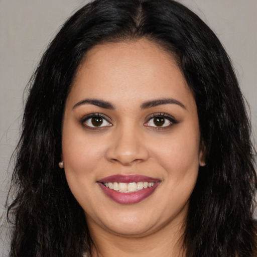 Joyful latino young-adult female with long  brown hair and brown eyes