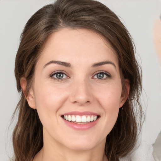 Joyful white young-adult female with medium  brown hair and grey eyes