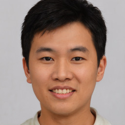 Joyful asian young-adult male with short  black hair and brown eyes