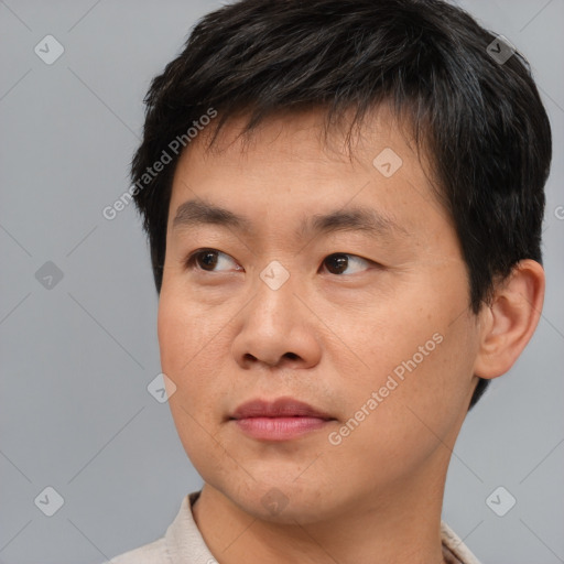 Joyful asian young-adult male with short  brown hair and brown eyes