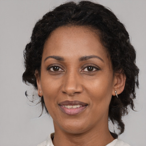 Joyful black adult female with medium  brown hair and brown eyes