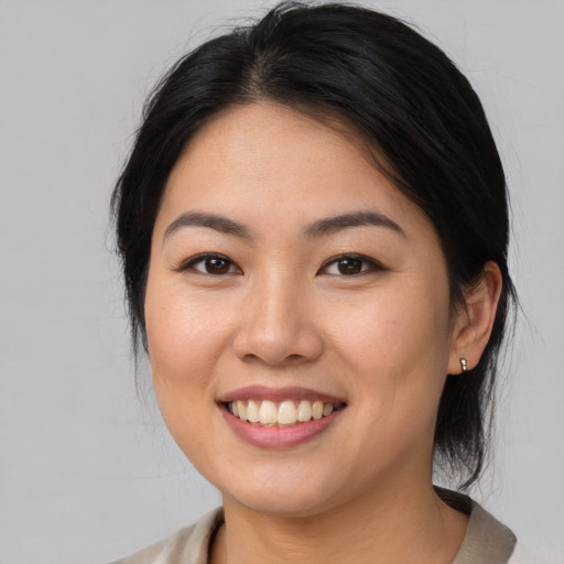 Joyful asian young-adult female with medium  brown hair and brown eyes