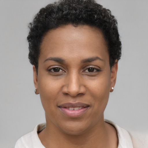 Joyful black young-adult female with short  black hair and brown eyes