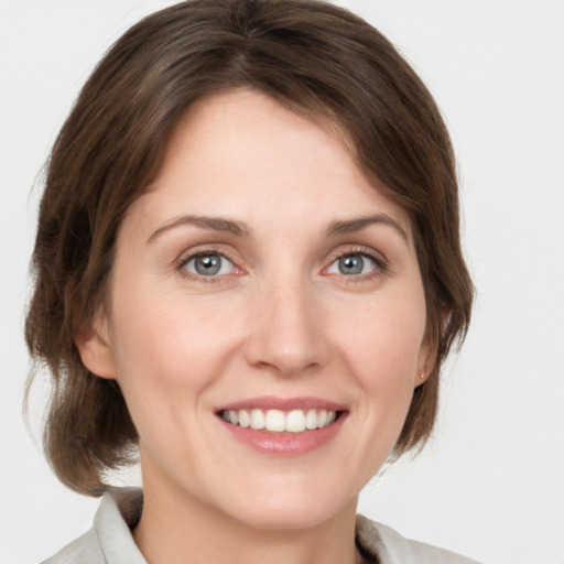 Joyful white young-adult female with medium  brown hair and grey eyes