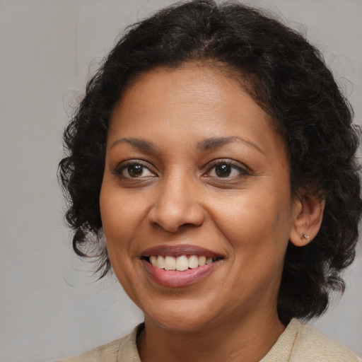 Joyful latino adult female with medium  brown hair and brown eyes