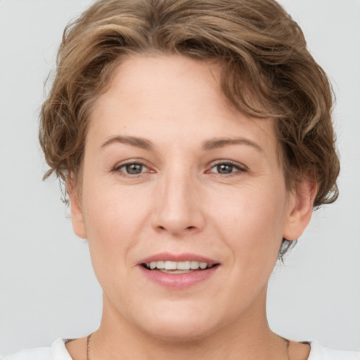 Joyful white adult female with short  brown hair and grey eyes