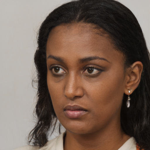 Neutral black young-adult female with medium  brown hair and brown eyes