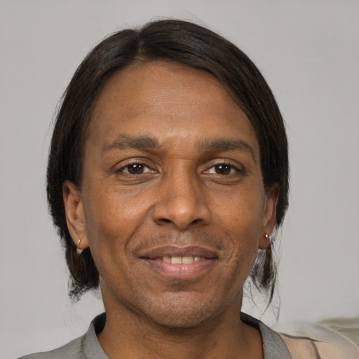 Joyful black adult male with short  black hair and brown eyes