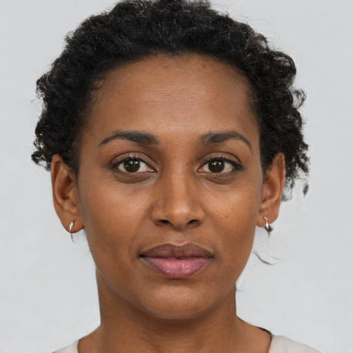 Joyful black adult female with short  brown hair and brown eyes