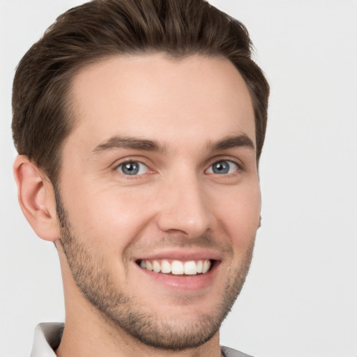 Joyful white young-adult male with short  brown hair and grey eyes