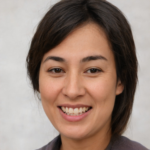 Joyful white young-adult female with medium  brown hair and brown eyes