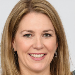 Joyful white adult female with long  brown hair and green eyes