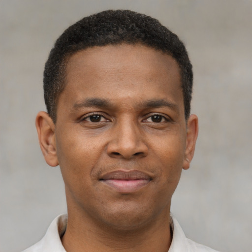 Joyful black young-adult male with short  brown hair and brown eyes