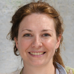 Joyful white adult female with medium  brown hair and blue eyes