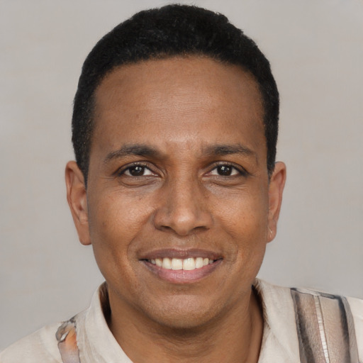 Joyful black adult male with short  black hair and brown eyes