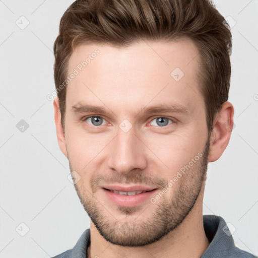 Joyful white young-adult male with short  brown hair and grey eyes