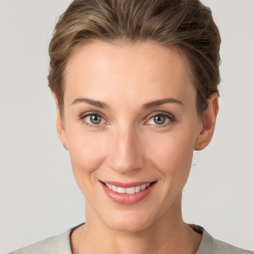 Joyful white young-adult female with short  brown hair and grey eyes