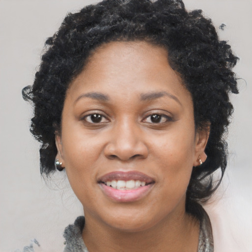 Joyful black adult female with medium  brown hair and brown eyes