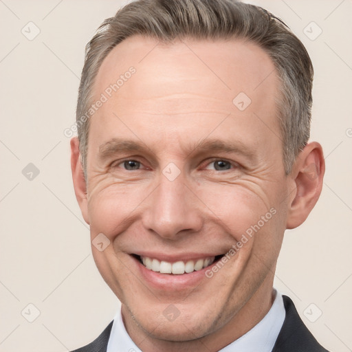 Joyful white adult male with short  brown hair and grey eyes