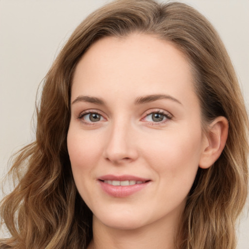 Joyful white young-adult female with long  brown hair and green eyes