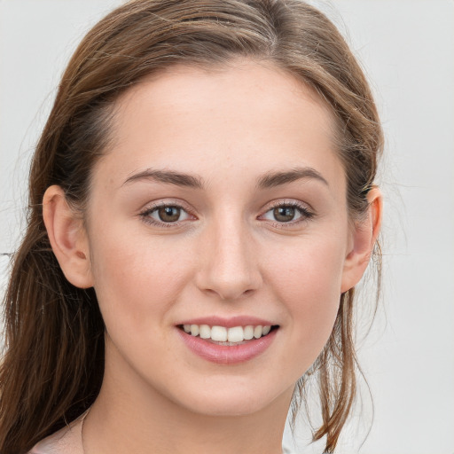 Joyful white young-adult female with long  brown hair and blue eyes