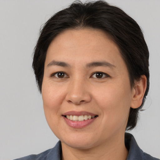 Joyful asian adult female with medium  brown hair and brown eyes