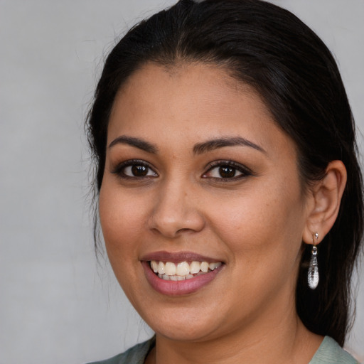 Joyful latino young-adult female with medium  brown hair and brown eyes
