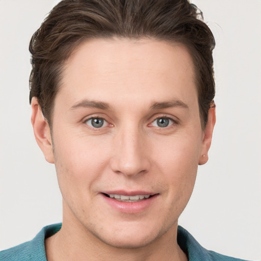 Joyful white young-adult male with short  brown hair and grey eyes