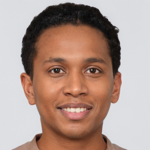 Joyful black young-adult male with short  black hair and brown eyes
