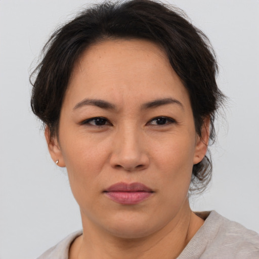 Joyful asian adult female with short  brown hair and brown eyes