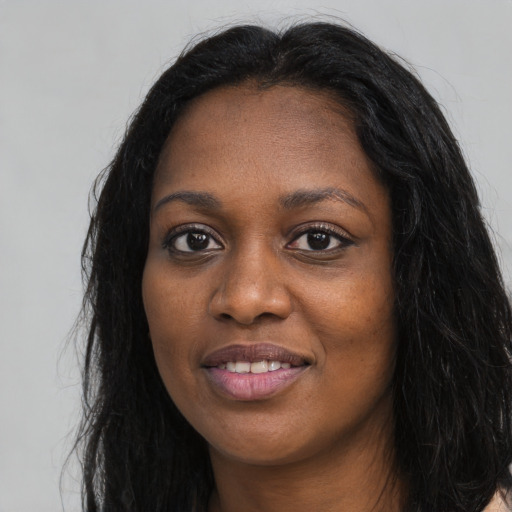 Joyful black young-adult female with long  black hair and brown eyes